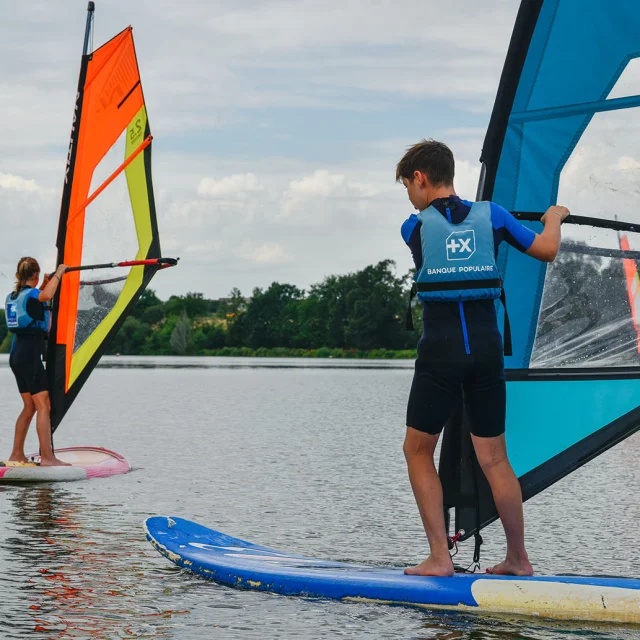 Deux adolescents apprennent à faire de la planche à voile