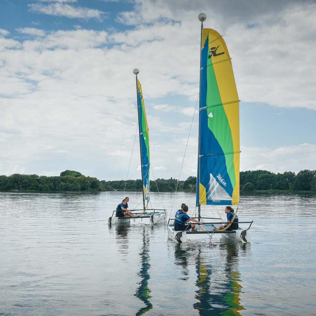 Deux catamarans naviguent sur le plan d'eau de La Rincerie