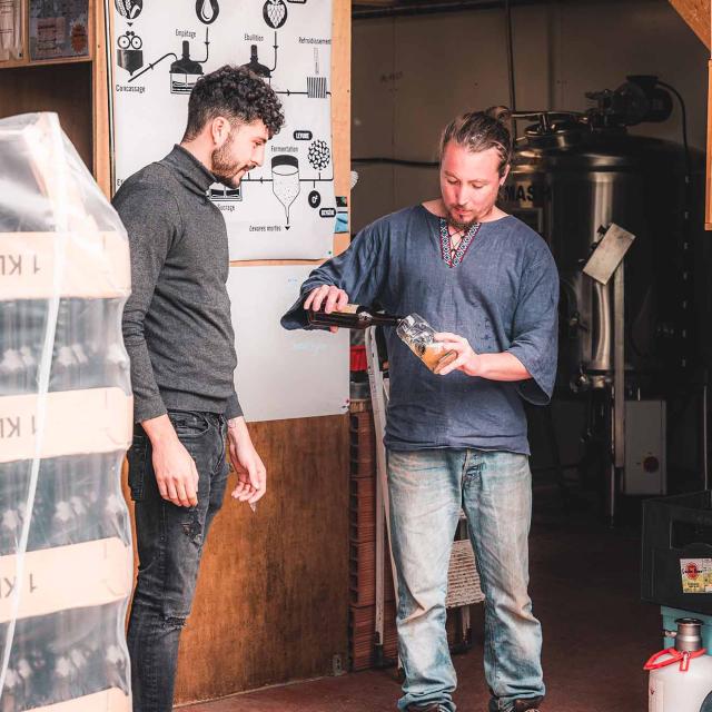 Guillaume servant une bière dans sa brasserie