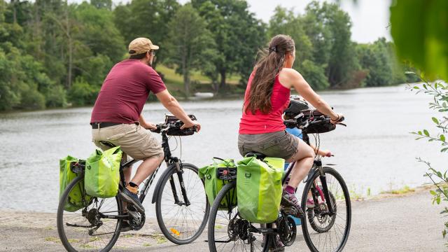 Un couple à vélo longe la rivière La Mayenne par le chemin de halage