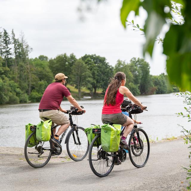 Un couple à vélo longe la rivière La Mayenne par le chemin de halage