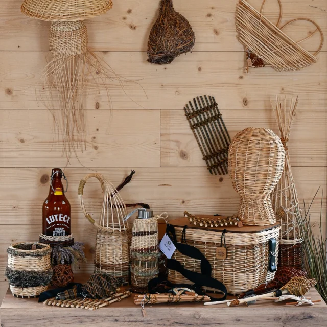 Sur une table en bois massif, des création de Judith Charpentier sont exposées : paniers, porte bouteille, cache pot...