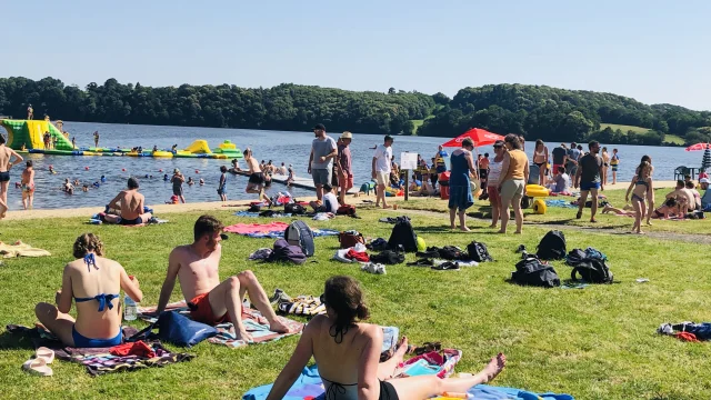 Des gens se baignent dans le lac de Haute Mayenne ou se repose sur la plage